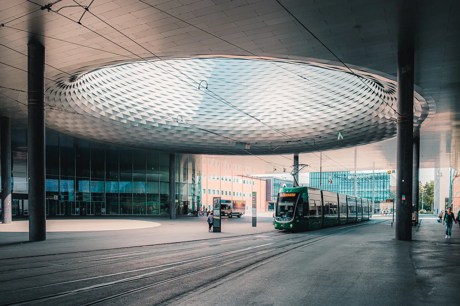 Un tram passant sous la grande canopée ajourée du Messe Basel.